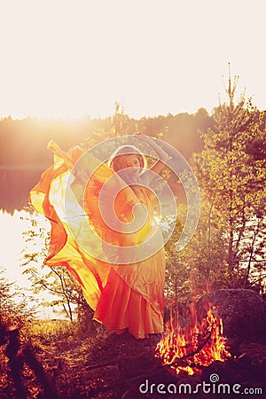 Beauty witch in the woods near the fire. Magic woman celebrating Stock Photo