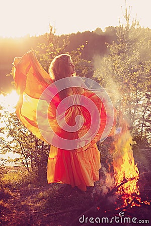 Beauty witch in the woods near the fire. Magic woman celebrating Stock Photo
