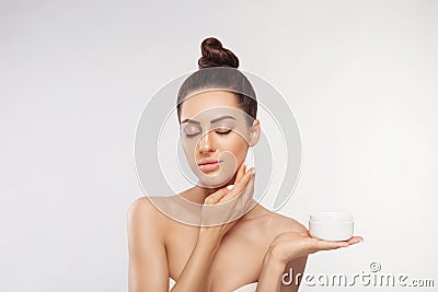 Beauty Woman Face Skin Care. Portrait Of Attractive Young Female Applying Cream And Holding Bottle. Closeup Of Smiling Girl With N Stock Photo