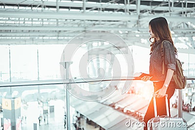 Beauty woman waiting for take off flight in airport. Asian woman with trolley suitcase. People and lifestyles concept. Stock Photo