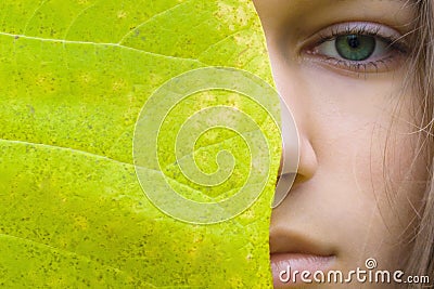 Beauty young blonde woman with green eyes without make up. Teen girl model and big green leaf Stock Photo