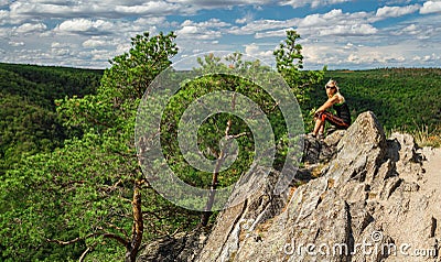 Beauty young woman sit on rockfrom side. Outdoor, fitness concept. national park Podyji, Czech republic Stock Photo