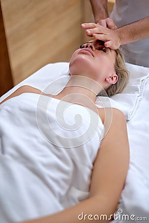 Beauty and youth. Hands of the masseuse make massage for beautiful charming woman Stock Photo