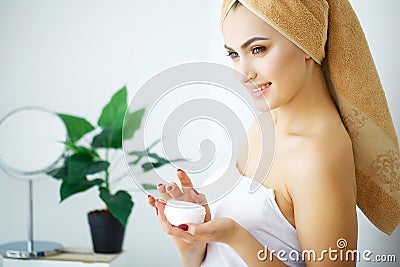 Beauty Youth Skin Care Concept - Close up Beautiful Caucasian Woman Face Portrait applying some cream to her face for skin care. Stock Photo