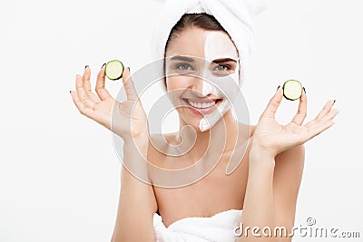 Beauty Youth Skin Care Concept - Portrait Beautiful Caucasian Woman apply cream and holding fresh cucumber in front of Stock Photo