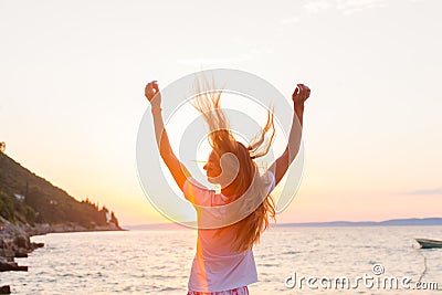 A beautyful woman feeling free meeting sun near the sea Stock Photo