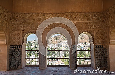 Beautyfull stucco walls decoration with arches in Mexuar section in Nasrid palace with Albacin old town view, Alhambra castle, Stock Photo