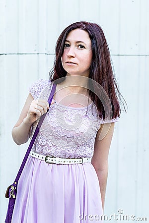 Pretty caucasian woman in a summer dress standing outside on white door background Stock Photo