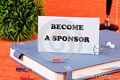 BECOME A SPONSOR text written on a business card standing with a clip on a diary, a notebook on an orange background Stock Photo