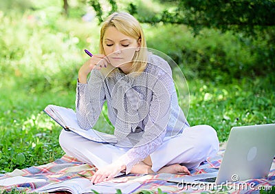 Become successful freelancer. Woman with laptop sit on rug grass meadow. Girl with notepad write note. Business lady Stock Photo