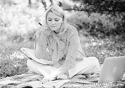 Become successful freelancer. Woman with laptop sit on rug grass meadow. Girl with notepad write note. Business lady Stock Photo