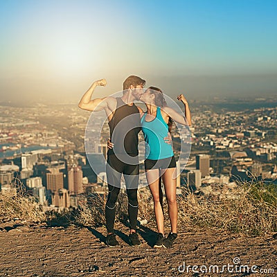 Become a workout power couple. a young couple flexing their muscles while out for a workout. Stock Photo