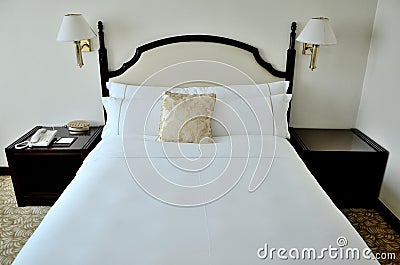 Bed in hotel room with golden pillow Stock Photo