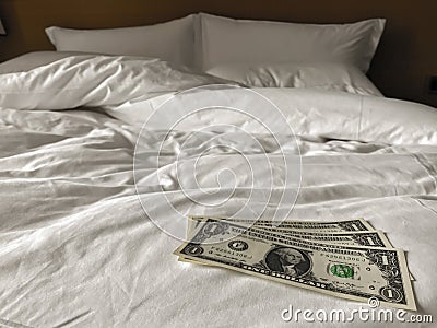 Bed and money to symbolize the cost of sex. Paid love the prostitute. Payment for the services of prostitutes. A tip for the staff Stock Photo