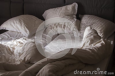 Bed sheet pillows and blanket messed up in morning Stock Photo