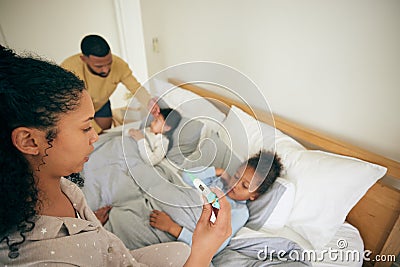 Bed, thermometer check and children sick from cold virus, fever or disease with worried mother helping, aid or family Stock Photo