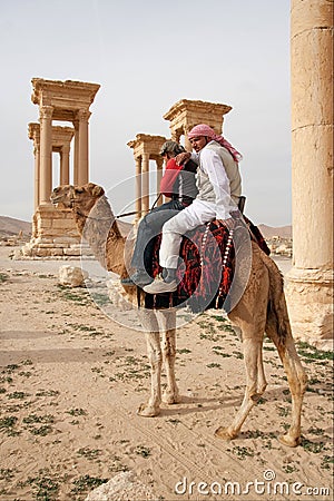 Bedouin boys riding camel in ancient city of Palmyra - Syria Editorial Stock Photo