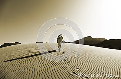 Bedouin Walking on the Sand Dunes in Wadi Rum Desert, Jordan in Sepia Colour Stock Photo