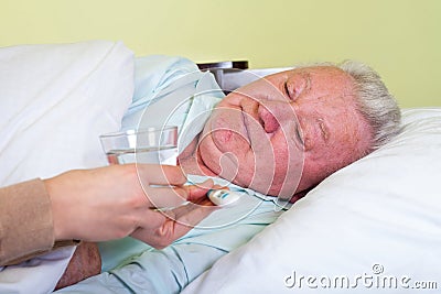 Bedridden elderly man having high temperature Stock Photo
