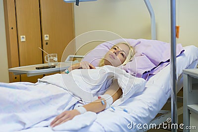 Bedridden female patient recovering after surgery in hospital care. Stock Photo