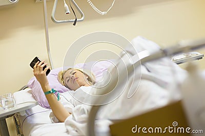 Bedridden female patient recovering after surgery in hospital care. Stock Photo