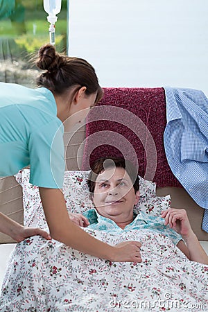 Bedridden woman and helpful nurse Stock Photo