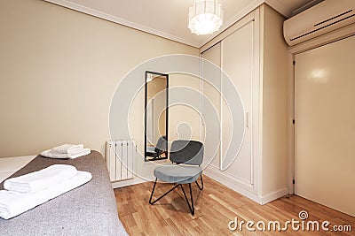 Bedroom with bed, built-in wardrobe, air conditioning unit Stock Photo