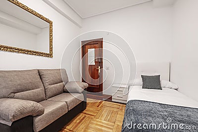 Bedroom with 90 bed, white bedside table, gold-framed mirror Stock Photo