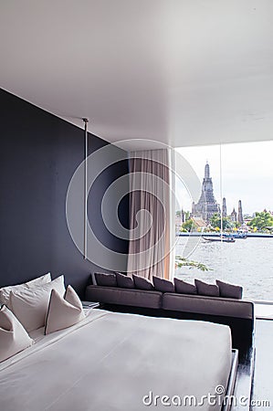 Bedroom with black wall white bed, pillows couch, lamp. Bay wind Editorial Stock Photo