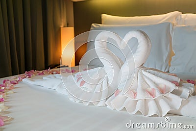 Bedroom with couple swans from the towel on white bed Stock Photo