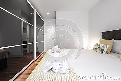 Bedroom with a king size bed with a large gloss black sliding door Stock Photo