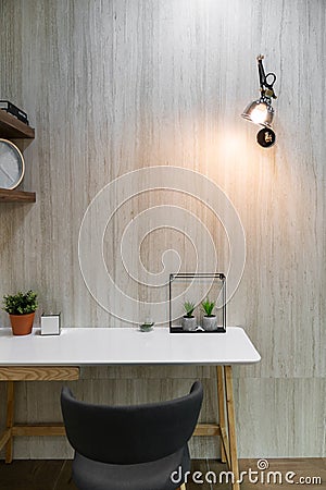 Bedroom working corner decorated with artificial plants and wall lamp with marble wall in the background /apartment interior Stock Photo