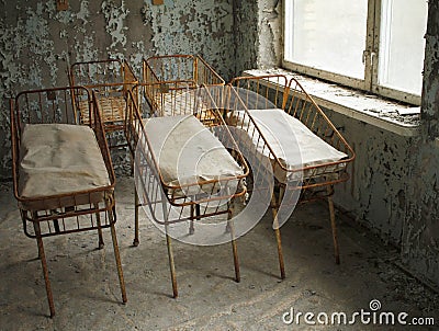 Beds for newborn babies in deserted hospital in Pripyat, Chernobyl, Ukraine. Stock Photo