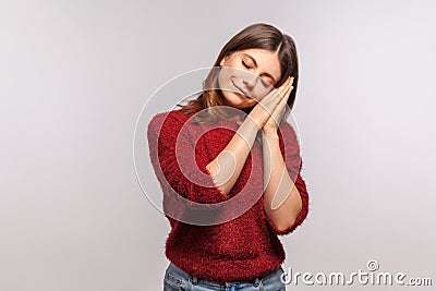 Bedtime. Portrait of girl in shaggy sweater sleeping laying down on her palms and smiling pleased, nap and rest Stock Photo