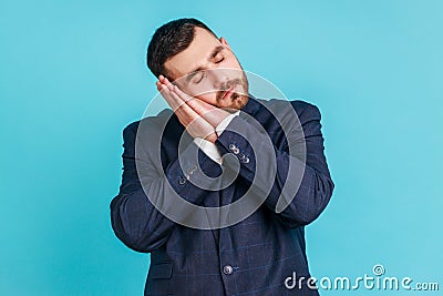 Bedtime. Portrait of handsome bearded man in suit sleeping laying down on her palms and smiling Stock Photo