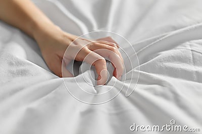 Hand of woman squeezing white bed sheet Stock Photo