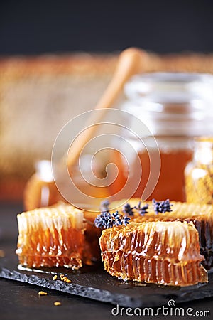 Bee pollen granules, honey jar with wooden dropper, honeycomb on dark backdrop. Copy space. Autumn harvest concept Stock Photo