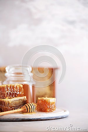 Bee pollen granules, honey jar with wooden dropper, honeycomb on grey backdrop. Copy space. Autumn harvest concept Stock Photo