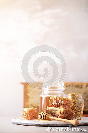 Bee pollen granules, honey jar with wooden dropper, honeycomb on grey backdrop. Copy space. Autumn harvest concept Stock Photo