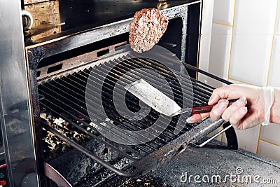 Beef Burger And Spatula On The Hot Flaming BBQ Charcoal Grill, Close-up Stock Photo