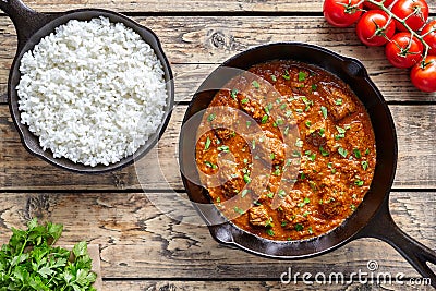 Beef Madras curry slow cook Indian spicy garam masala lamb food in cast iron pan Stock Photo