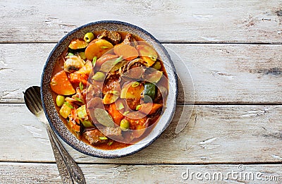 Beef meat and vegetables stew in a plate on natural wooden table Stock Photo