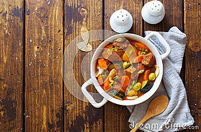 Beef meat and vegetables stew in white bowl on dark wooden table Stock Photo