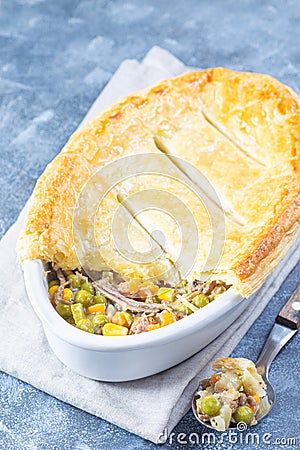 Beef pot pie or deep dish pie in baking dish, crust broken open, vertical, copy space Stock Photo