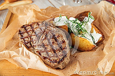Beef steak with baked potatoes with sour cream Stock Photo