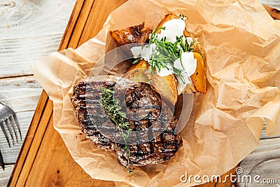 Beef steak baked potatoes sour cream pepper sauce Stock Photo