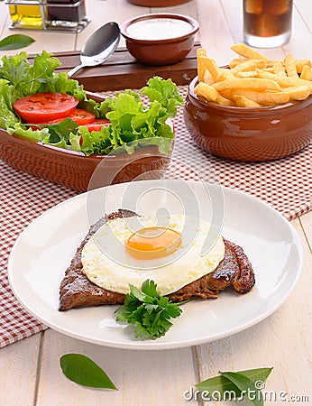 Beef steak Bife a Cavalo - Brazilian traditional food Steaks, White rice, farofa and salad Stock Photo