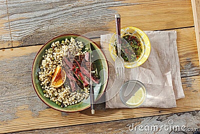 Beef steak grilled pearl barley couscous wooden table sauce water lemon top view Healthy food concept Stock Photo