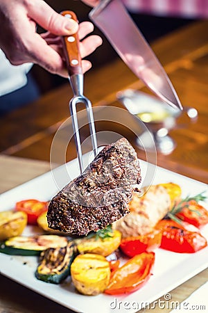 Beef Steak. Sirloin steak. Delicious juicy beef steak on fork. grill vegetables Stock Photo