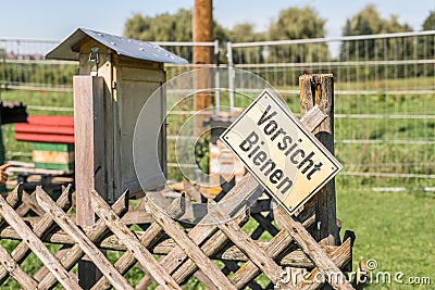 Beehive and insect hotel with a sign in German language - Caution bees, Germany Stock Photo